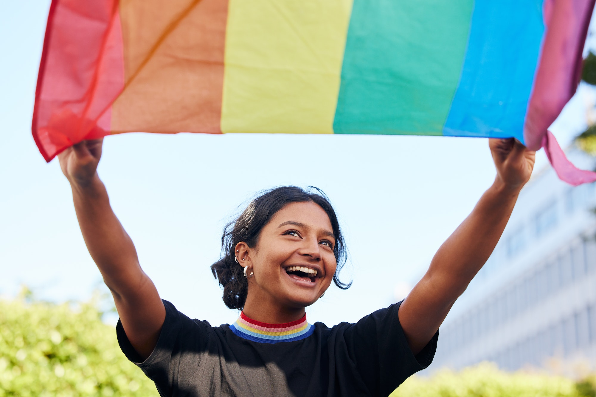 Rainbow, flag and lgbt with an indian woman in the city in celebration of human rights, equality or